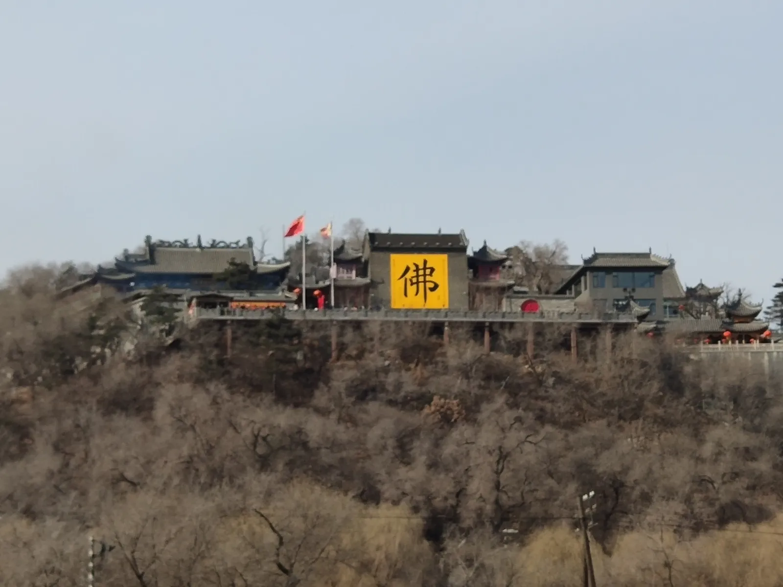 National flag and Buddhist flag flying in front of the temple cluster at Beishan Park, Jilin City
